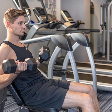 Meriton Suites North Ryde Sydney Exterior photo A man using a dumbbell to exercise