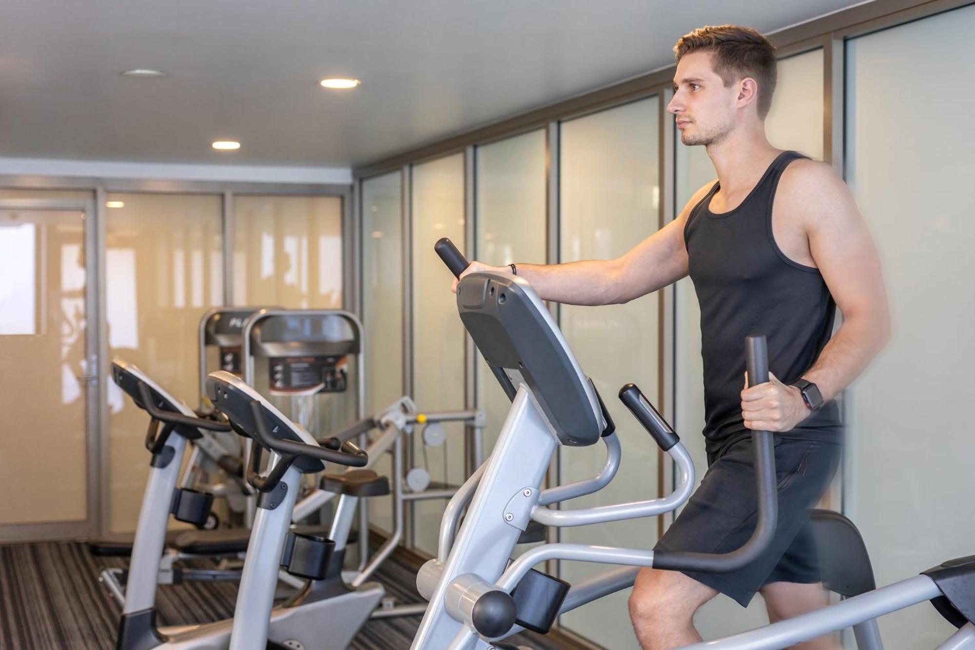 Meriton Suites North Ryde Sydney Exterior photo A man using an elliptical trainer